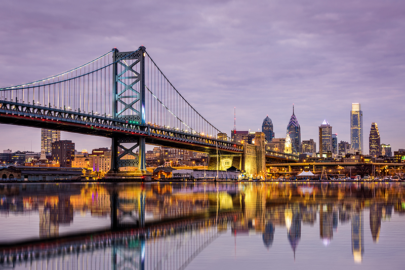 Ben Franklin bridge and Philadelphia skyline, under a purple sunset