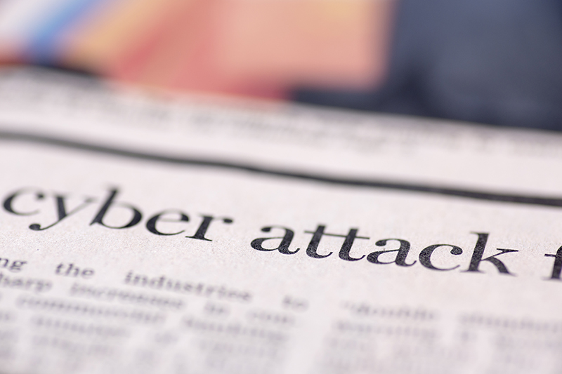 Cyber Attack headline on newspaper.