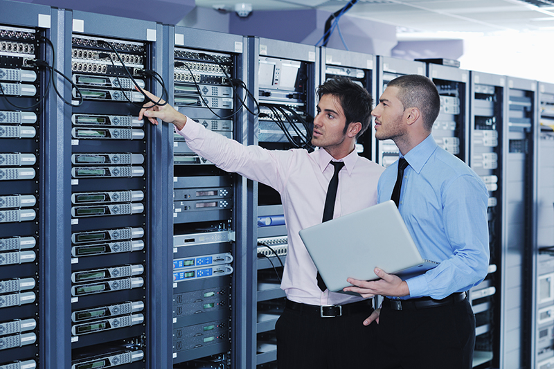IT engineers in network server room solving problems and giving IT support